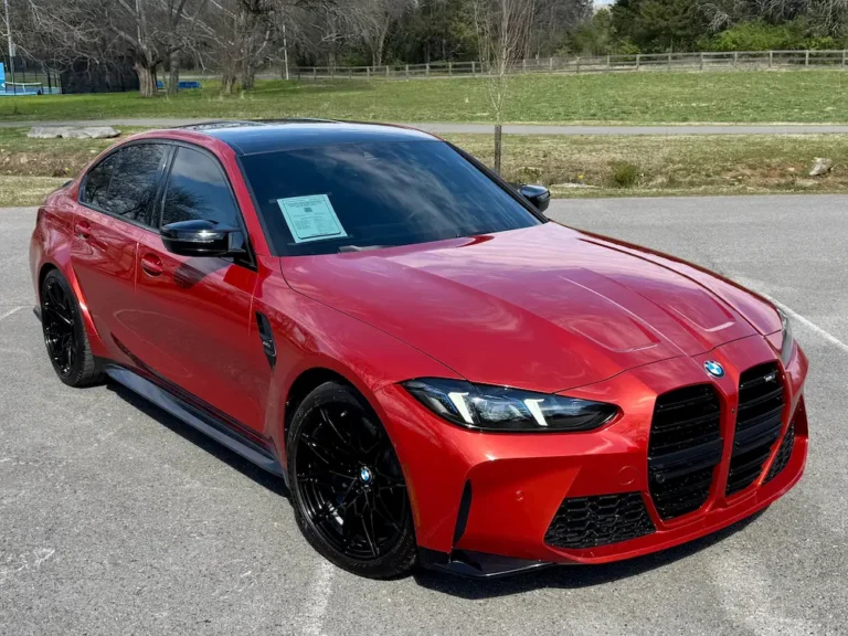 red BMW M3 sports sedan with black wheels parked on pavement