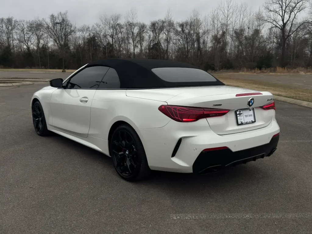 2025 BMW M440i convertible rear view white exterior black soft top