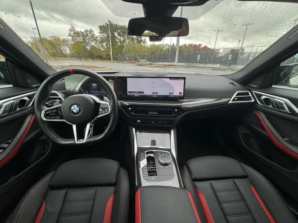 Interior cabin of 2025 BMW M440i with digital dash, leather seating, and sporty trim.