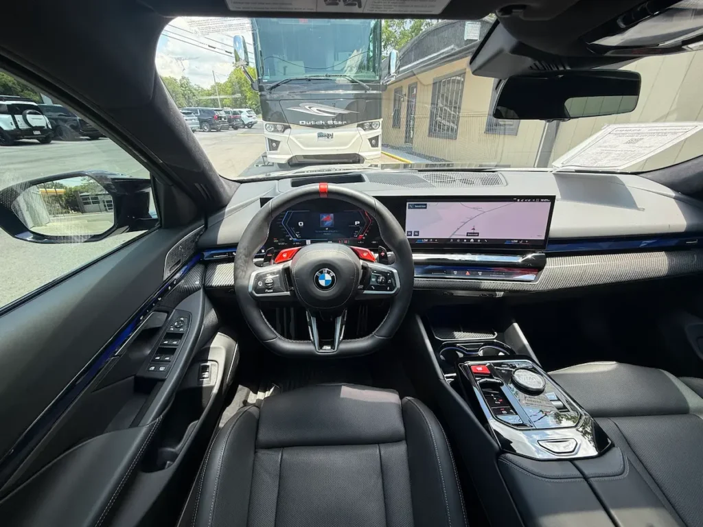 2025 BMW M5 cockpit with curved display and M performance steering wheel