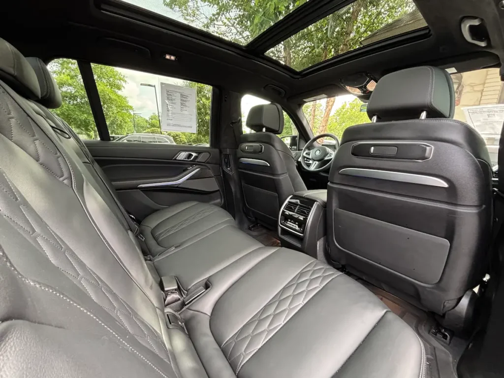 2025 BMW X7 M60i second-row leather seating with panoramic glass roof and rear climate controls