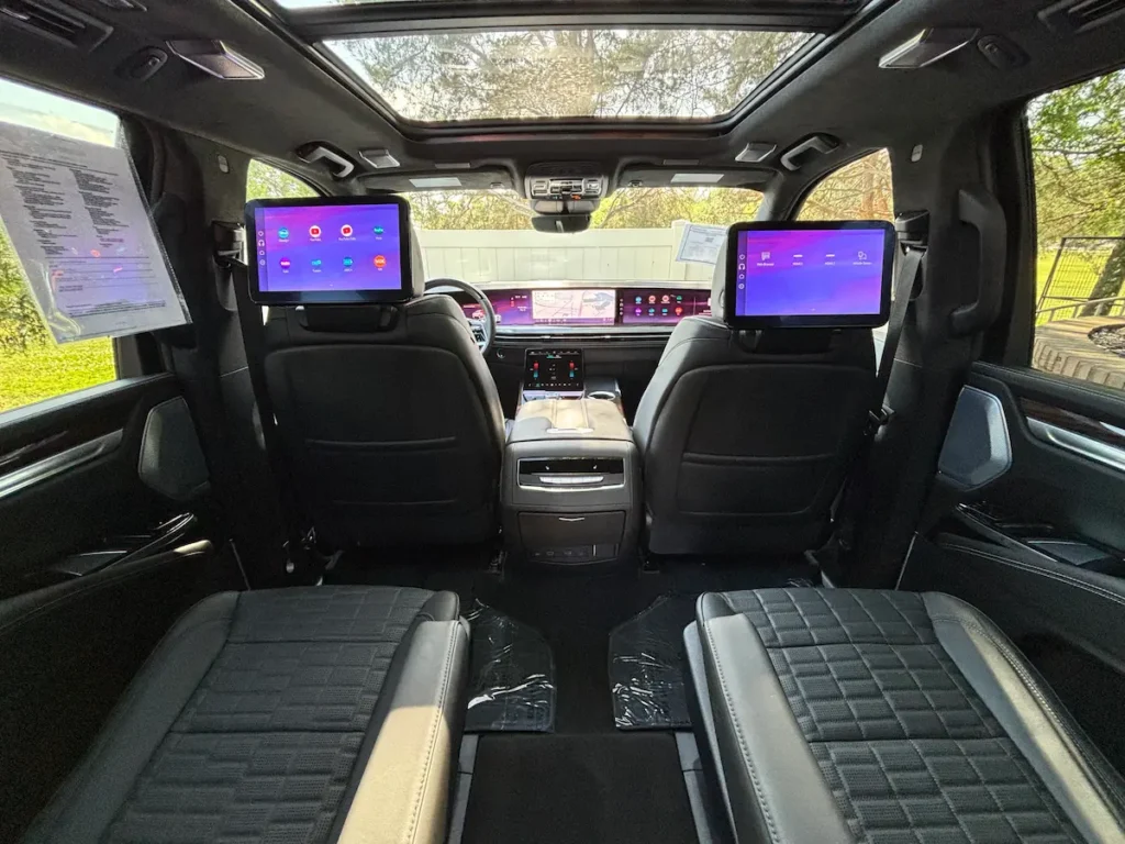2025 Cadillac Escalade interior with rear entertainment screens, luxury seating, and panoramic roof