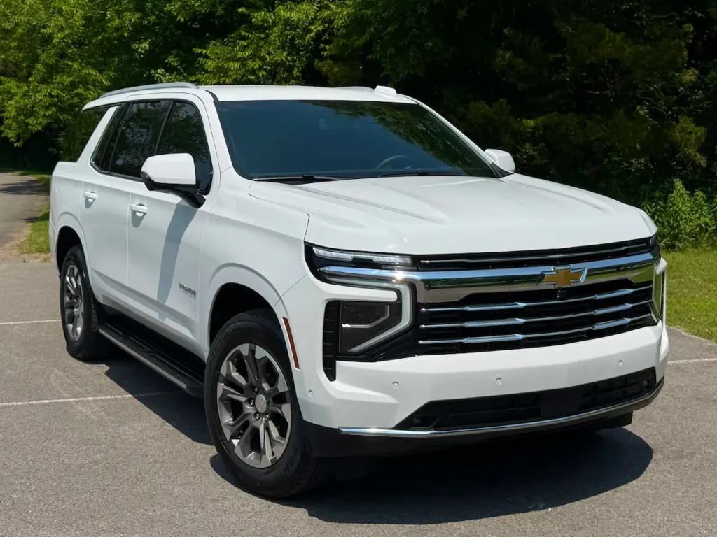 Front and side angle of a white 2025 Chevrolet Tahoe LT with modern LED lighting and chrome grille.