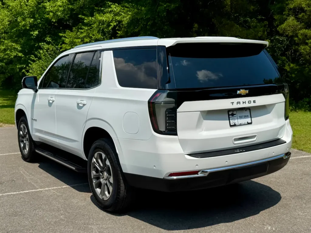Rear and side angle of a white 2025 Chevrolet Tahoe LT with black trim and tinted windows.