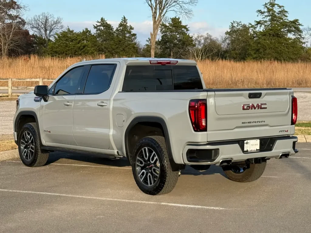 Rear exterior of a gray 2025 GMC Sierra 1500 AT4 showcasing taillights and bed design.