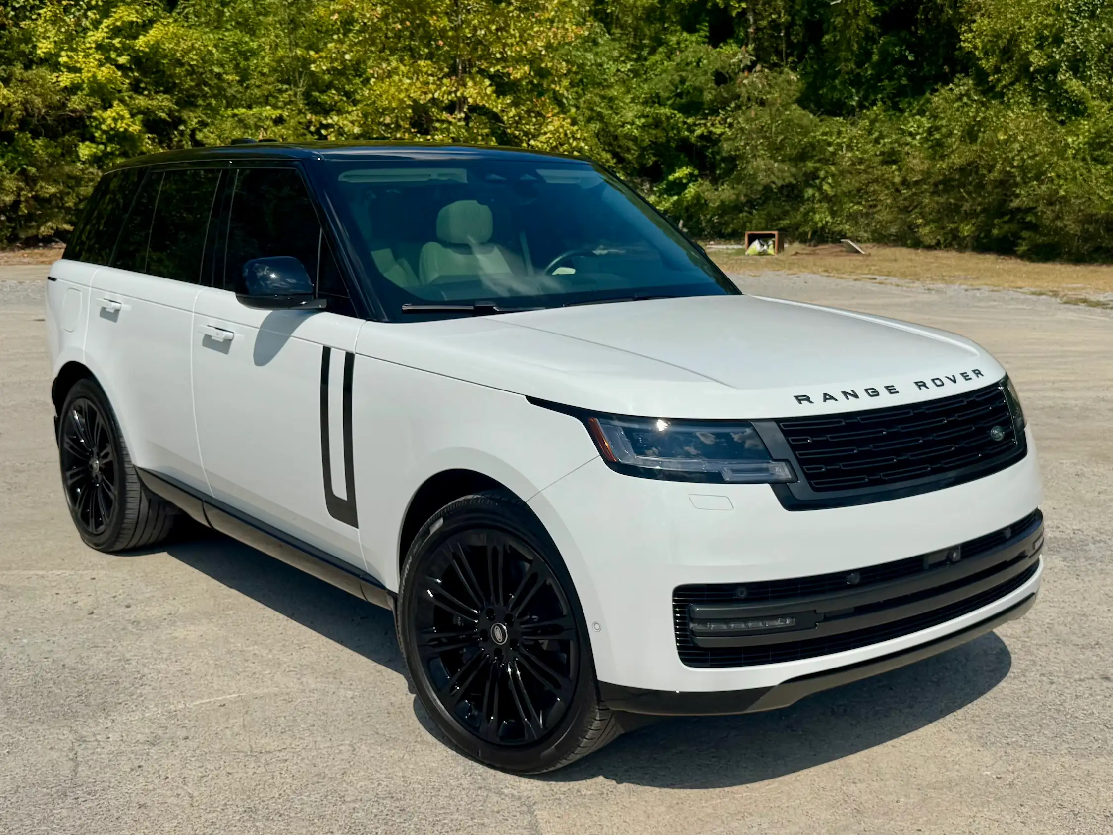 White 2025 Range Rover P530 SE in front three-quarter view with slim headlights, black wheels and a contrasting roof.
