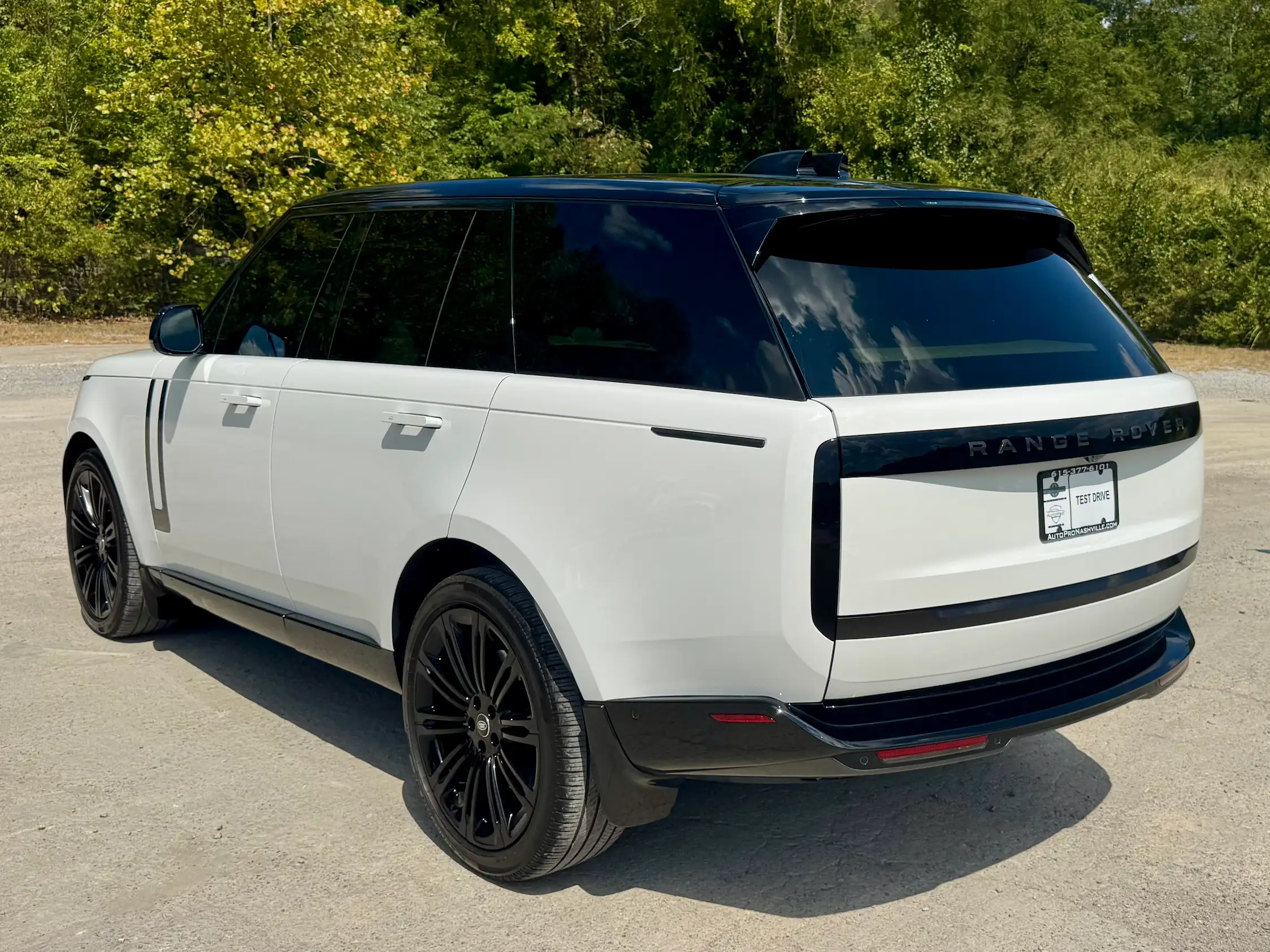 Rear three-quarter view of a white 2025 Range Rover P530 SE with flush door handles and dark vertical taillights.