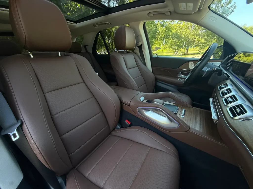 Front passenger and driver seats of 2025 Mercedes-Benz GLE 350 in brown leather with wood console.