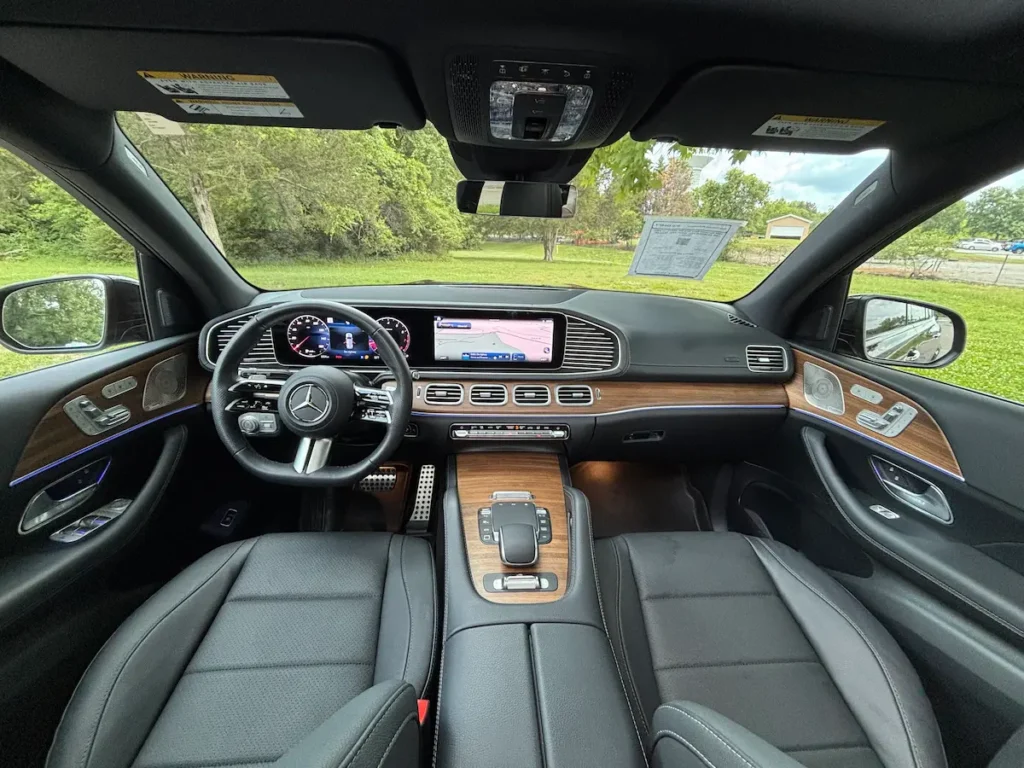 2025 Mercedes-Benz GLS 450 front interior with MBUX screens, wood trim, and leather seats