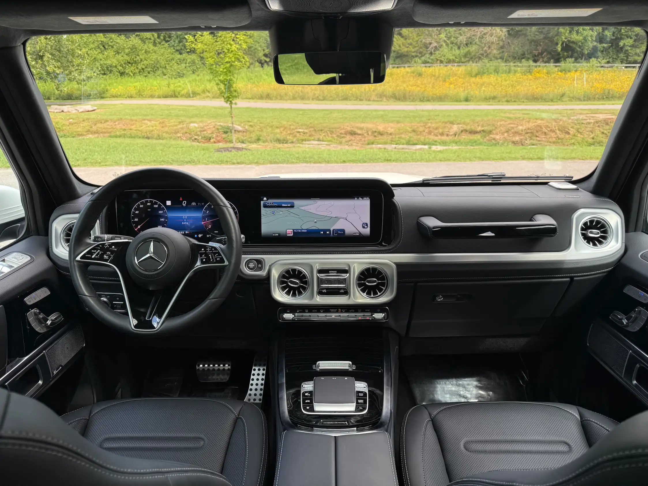 2025 Mercedes-Benz G 550 front interior with black seats, digital dashboard displays and circular air vents.