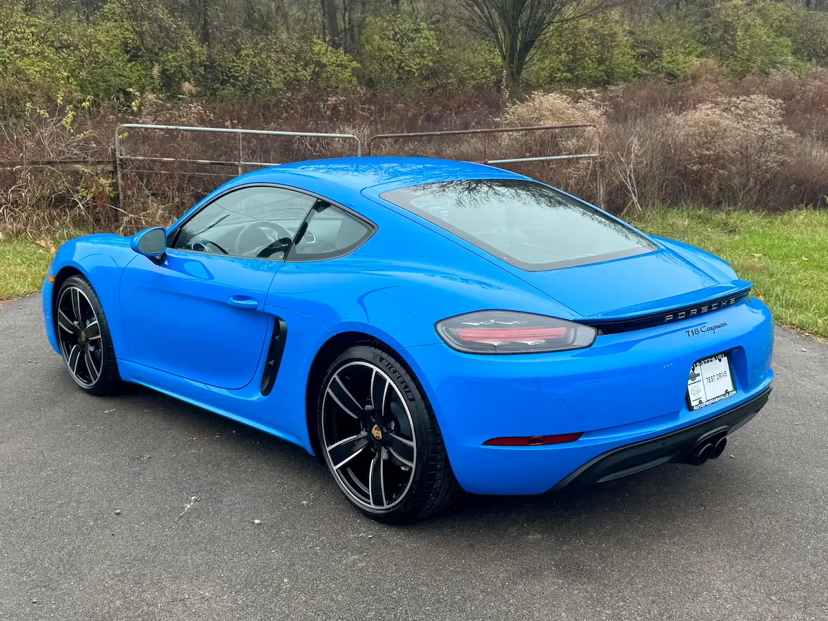 Rear view of a blue 2025 Porsche 718 Cayman with dual exhaust outlets