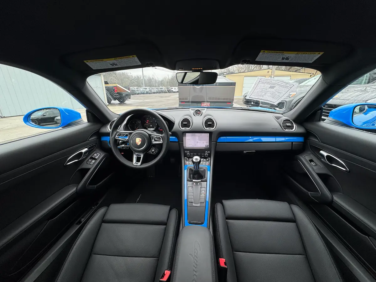 Centered view of the 2025 Porsche 718 Cayman dashboard and manual shifter