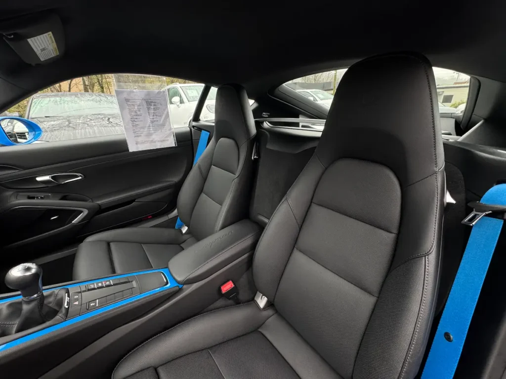 2025 Porsche 718 Cayman interior with black sport seats and blue accents