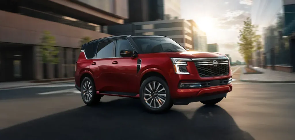 2025 Nissan Armada PRO-4X in red with a black contrasting roof, parked outdoors showcasing its rugged off-road stance.