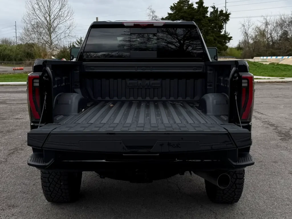 Open cargo bed of a black 2026 GMC Sierra 2500HD pickup truck