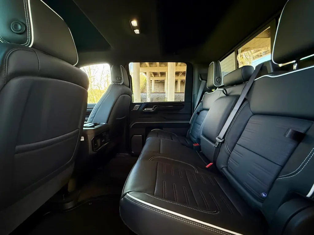 Rear-seat interior of a black 2026 GMC Sierra 2500HD AT4X with leather bench seating