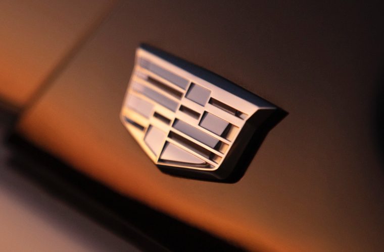 Close-up photo of a Cadillac emblem on a car grill.