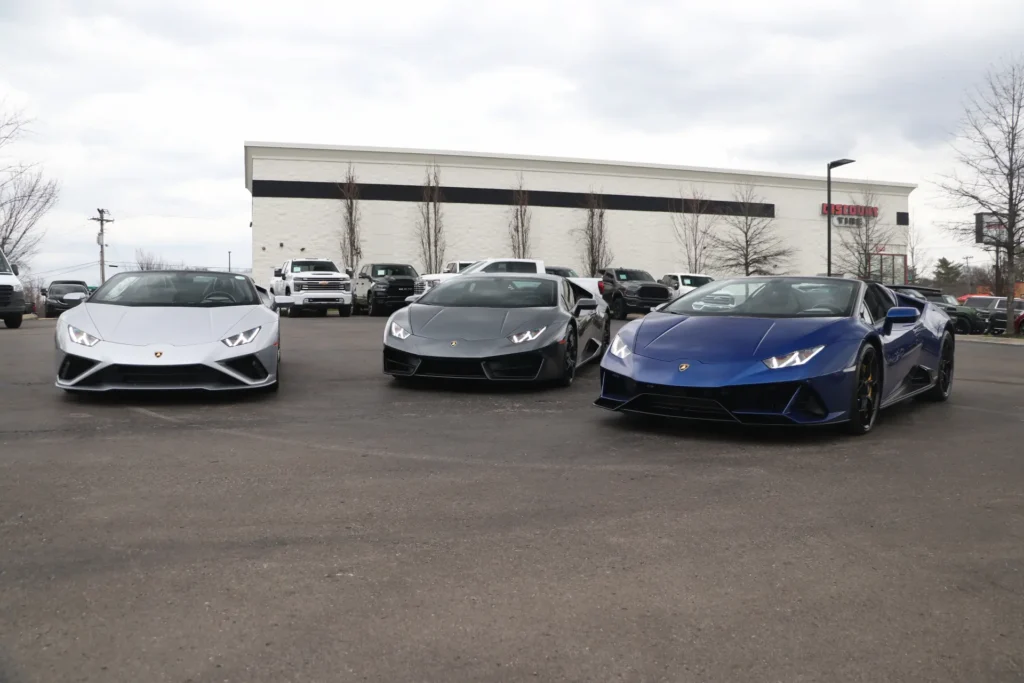Three Lamborghini sports cars parked in front of AutoPro Nashville, showcasing luxury and performance.