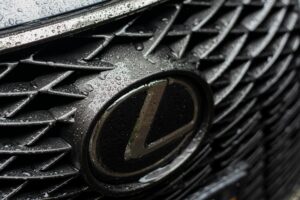 Close-up photo of the Lexus logo on the center dashboard of a white Lexus RX SUV.