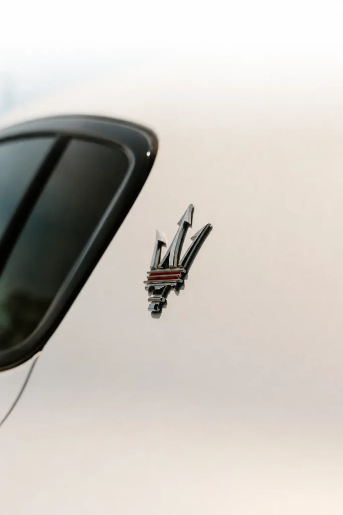 Close-up of the Maserati trident badge on a white Grecale luxury SUV