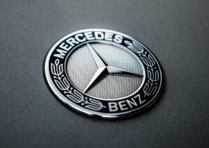 Close-up photo of a silver Mercedes-Benz emblem with three pointed star