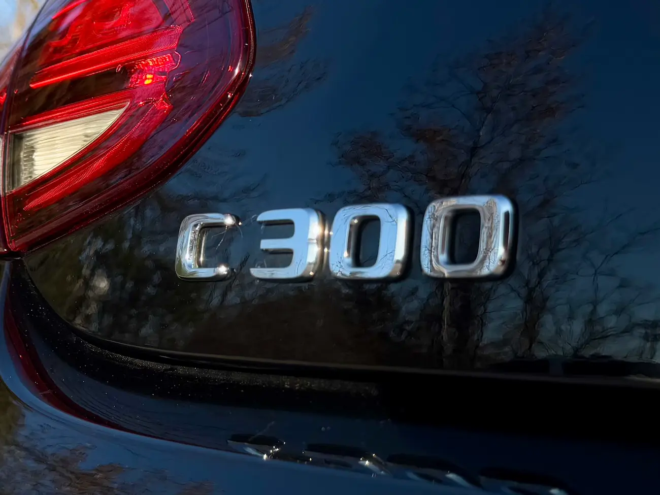 Close-up of the C 300 badge on a black Mercedes-Benz highlighting chrome detailing and sleek finish.