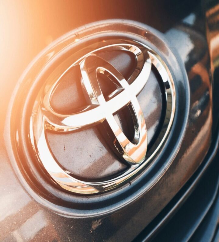 Close-up of a silver Toyota emblem on the grill of a car.