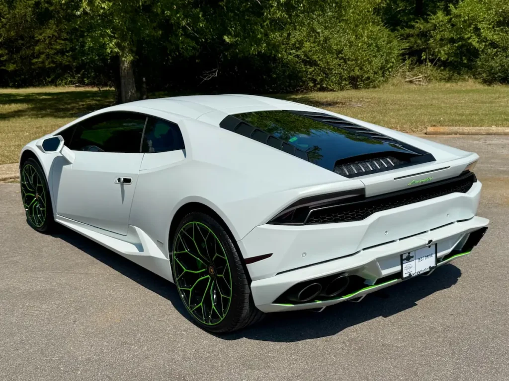 Rear angle of white Lamborghini Huracán LP 610-4 with green accent wheels.