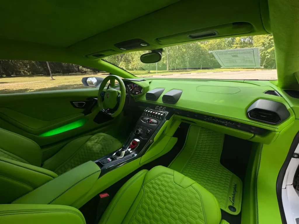 Interior of Lamborghini Huracán featuring green leather seats and dashboard.