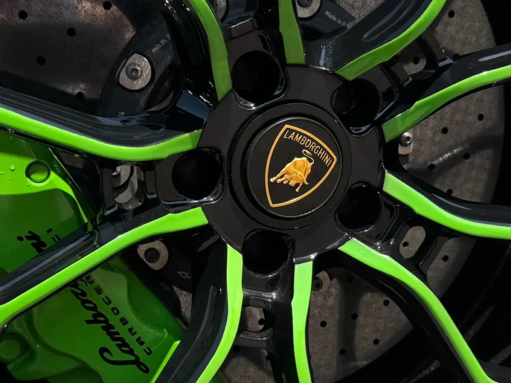Close-up of Lamborghini Huracán wheel with green trim and carbon-ceramic brakes.