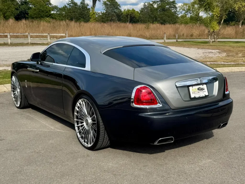 Rear three-quarter view of 2016 Rolls-Royce Wraith luxury coupe with chrome detailing and dual exhausts.