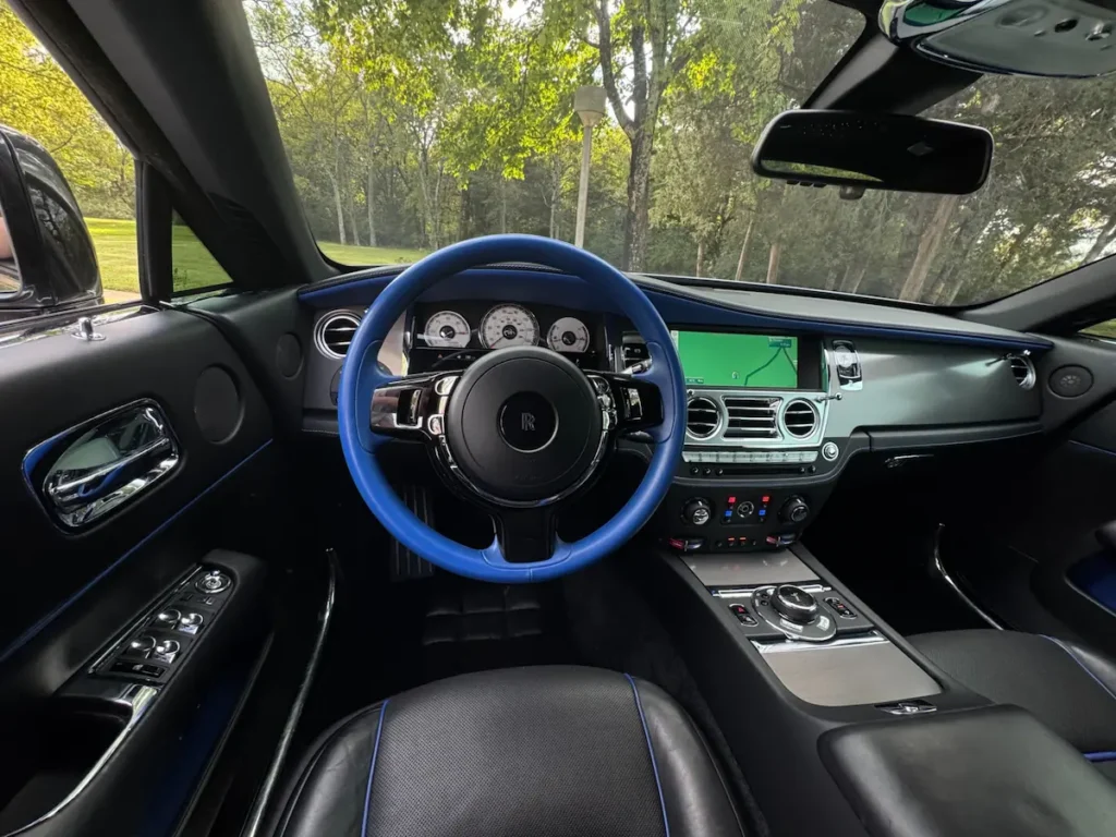 2016 Rolls-Royce Wraith steering wheel and dashboard with blue trim and analog gauges.
