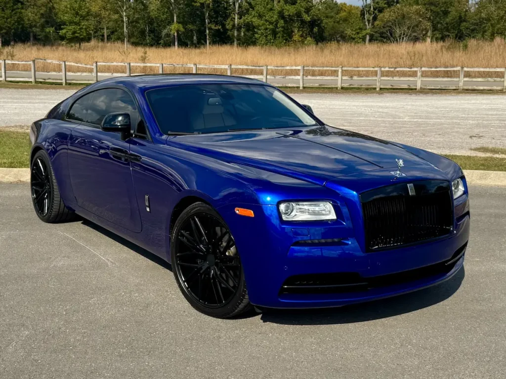 Front angle of 2016 Rolls-Royce Wraith in royal blue with black wheels.
