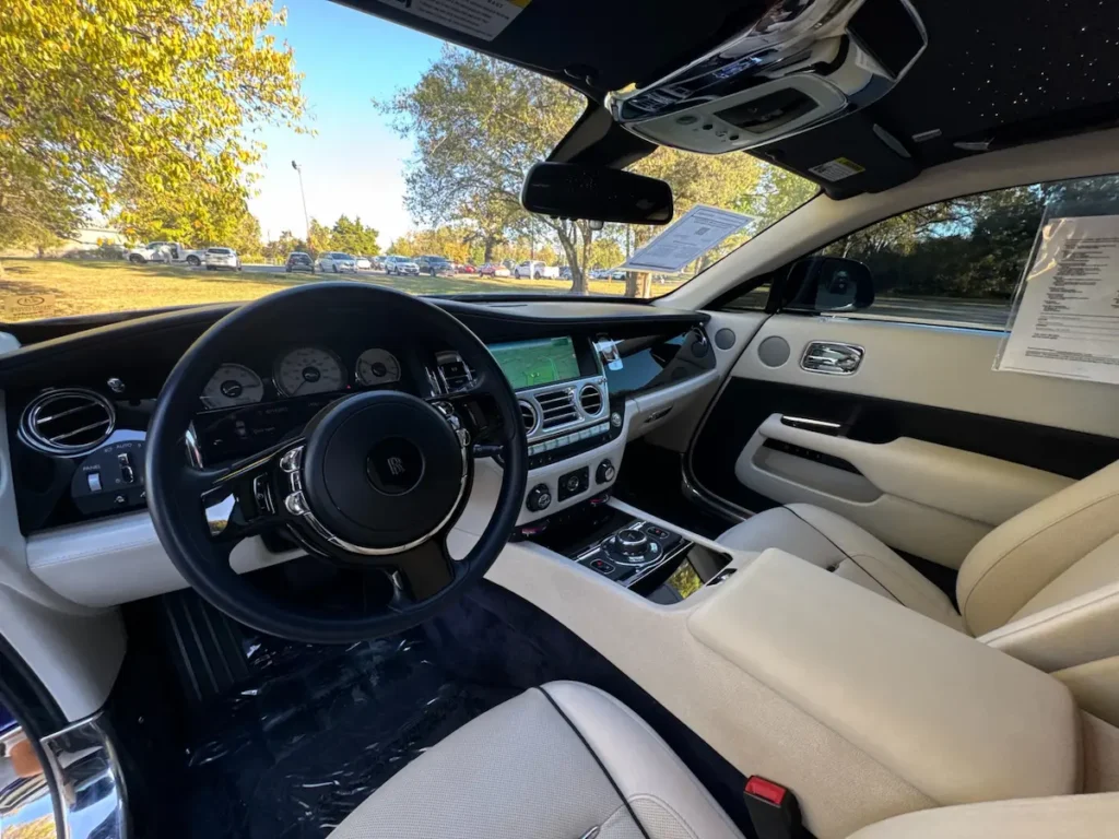 Interior view of Rolls-Royce Wraith featuring cream leather seats and chrome accents.