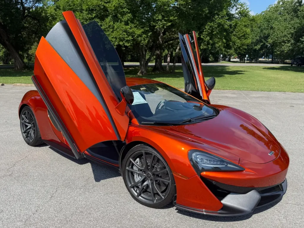 McLaren 570S with dihedral doors open, revealing lightweight carbon construction and supercar styling.