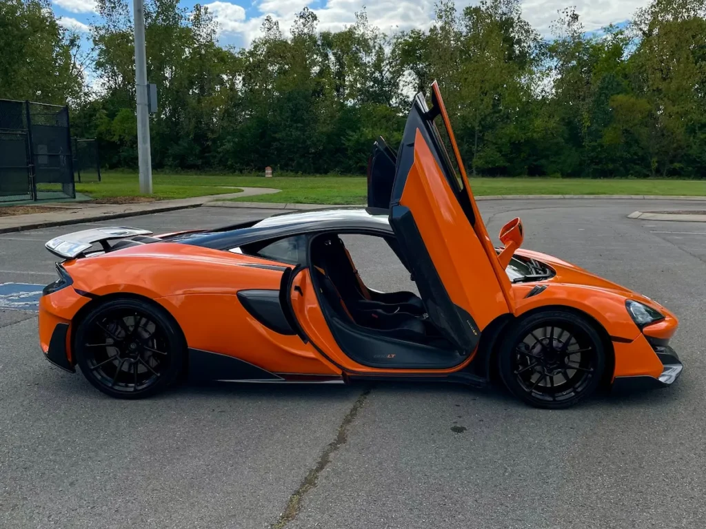 Side view of McLaren 600LT with doors open in a parking lot.