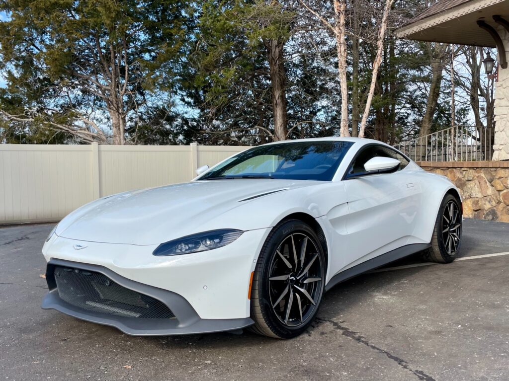 A white 2020 Aston Martin Vantage parked in a parking lot next to a building in AutoPro Nashville