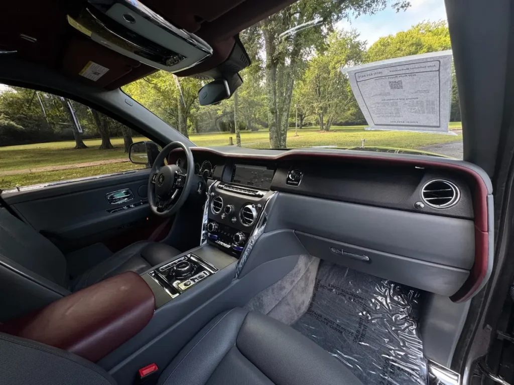 2020 Rolls-Royce Cullinan interior with red and black leather, digital display, and chrome control finishes.