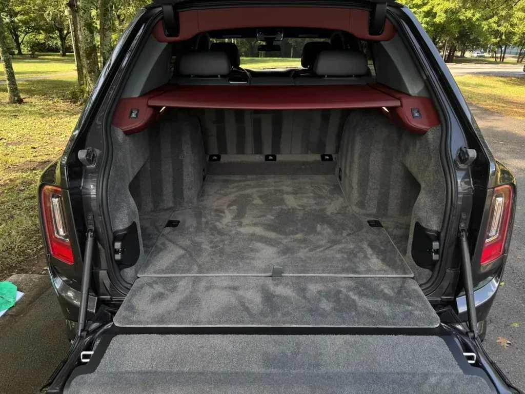 2020 Rolls-Royce Cullinan rear cargo space with premium carpeting and retractable privacy cover.