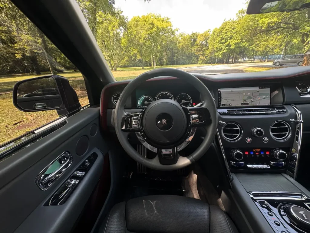 Steering and dashboard view of Rolls-Royce Cullinan with navigation display.