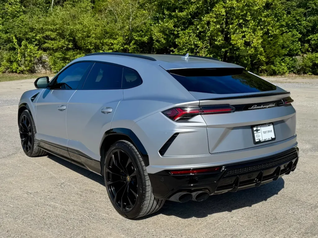 Rear angle of 2021 Lamborghini Urus in matte silver with black wheels.