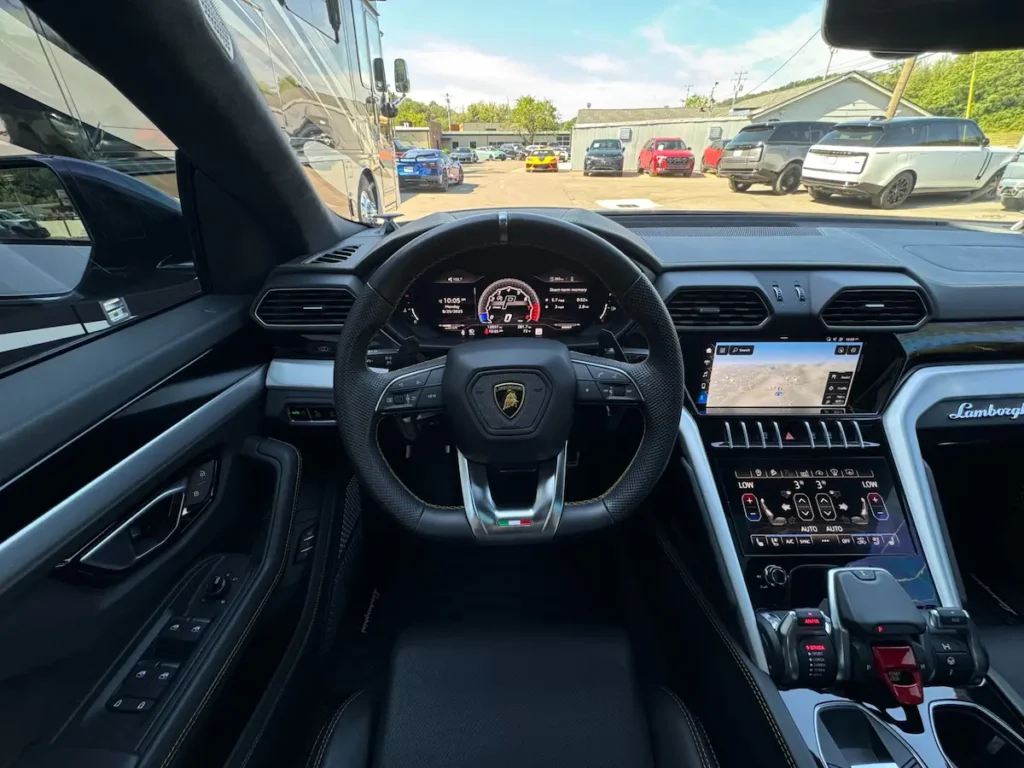 Interior view of 2021 Lamborghini Urus cockpit with digital display and navigation screen.