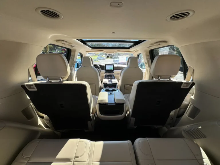 Interior view of the 2021 Lincoln Navigator Reserve from the rear seat, showcasing luxurious leather seating, a panoramic sunroof, and advanced technology features.