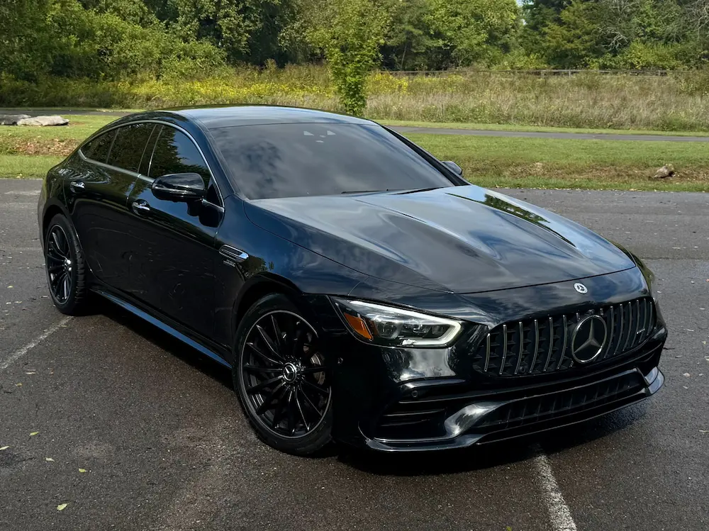 2021 Mercedes-AMG GT 53 4-Door Coupe in black featuring AMG grille and alloy wheels.