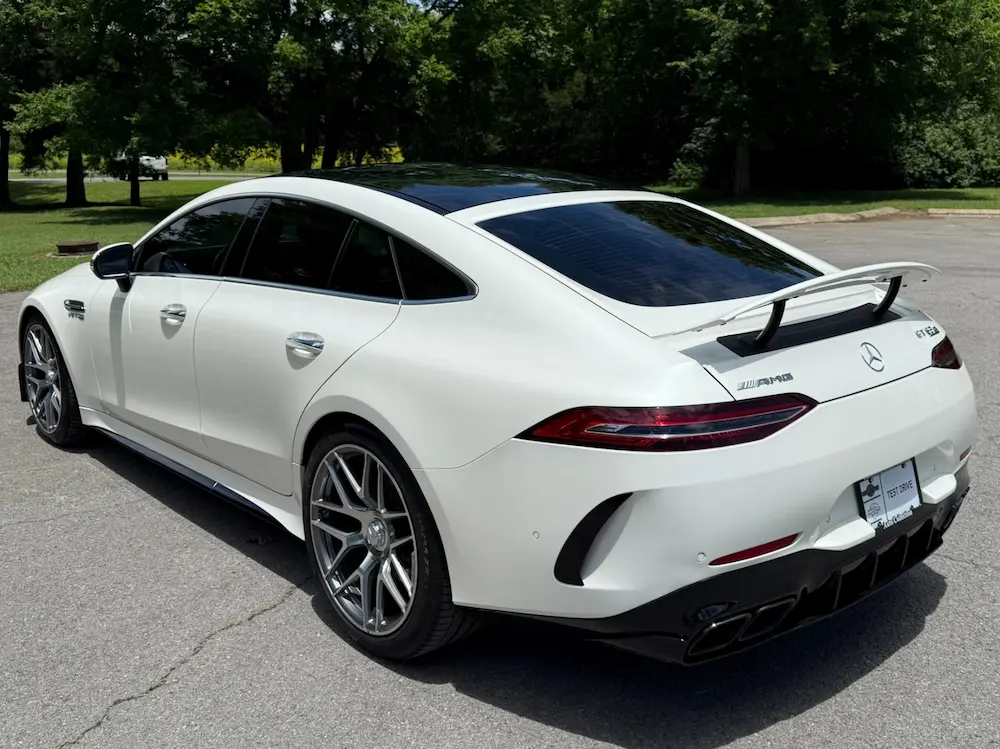 Rear of Mercedes-AMG GT 63 S 4MATIC+ in white featuring quad exhaust and aerodynamic spoiler.