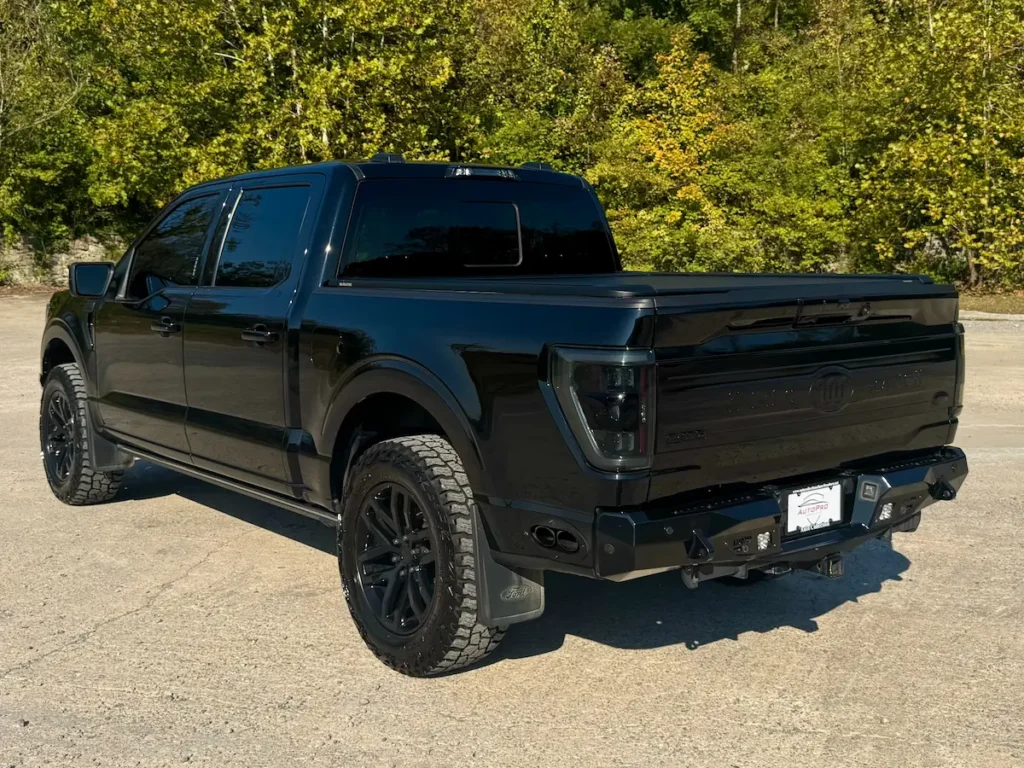 Rear view of a 2022 Ford F-150 King Ranch in black, showing sculpted tailgate and blacked-out LED taillights.