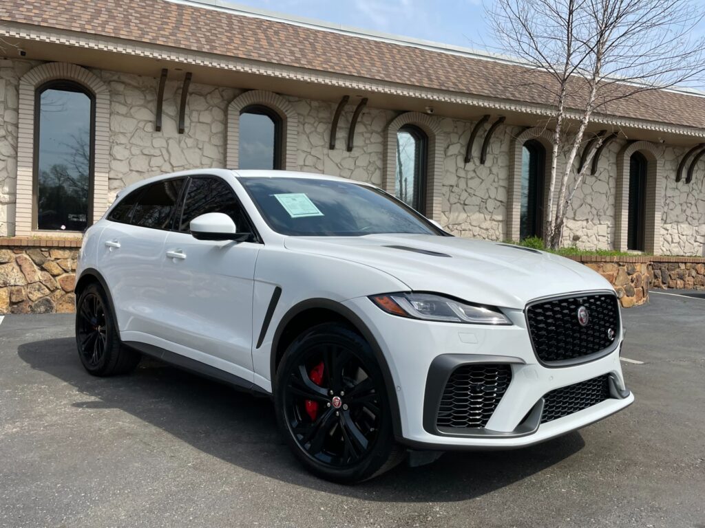 A white 2022 Jaguar F-PACE SVR SUV parked in front of a stone building.