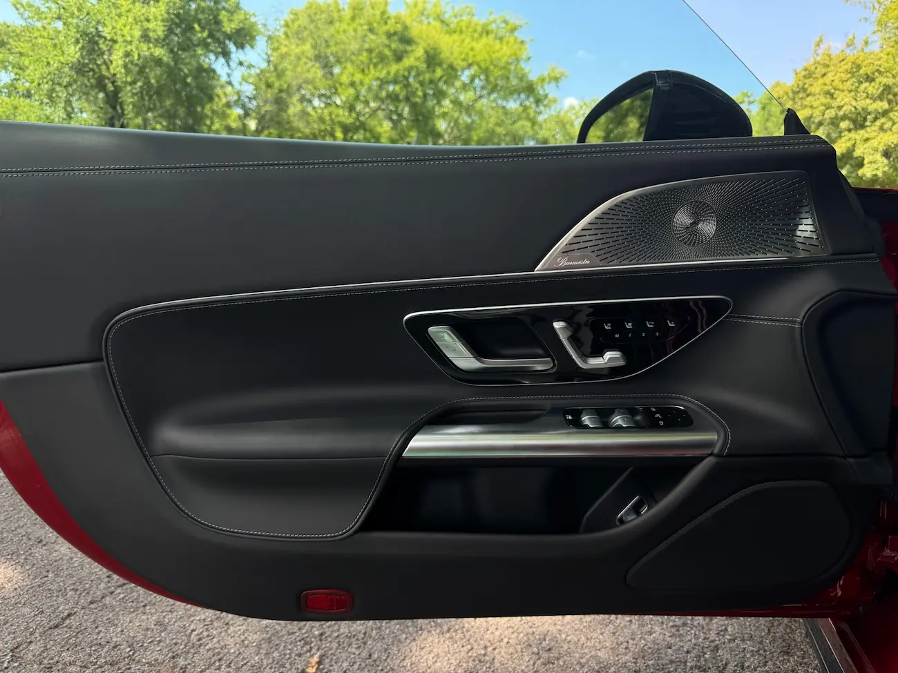 Close-up of 2022 Mercedes-AMG SL63 door panel with Burmester 3D surround sound system and premium leather stitching.