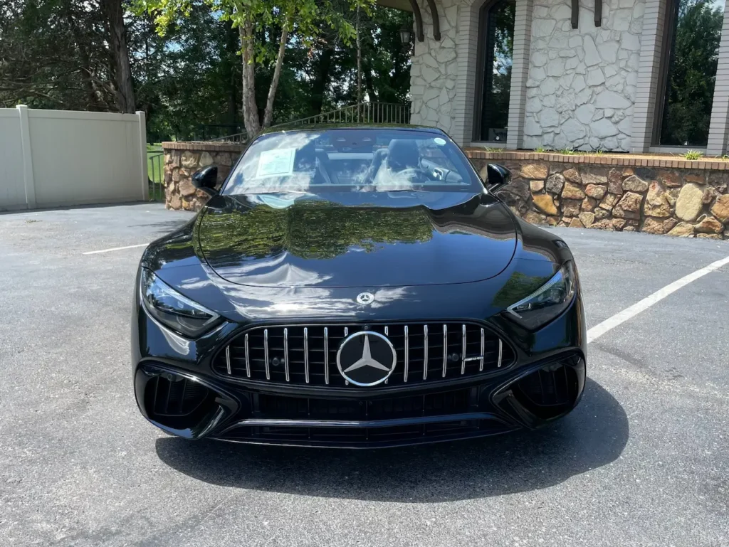Front view of a black 2022 Mercedes-AMG SL 63 Roadster showcasing AMG Panamericana grille and sleek LED headlights.