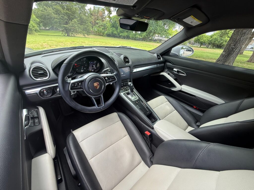 Interior cockpit of a 2022 Porsche 718 Cayman T with two-tone leather seats and PDK transmission